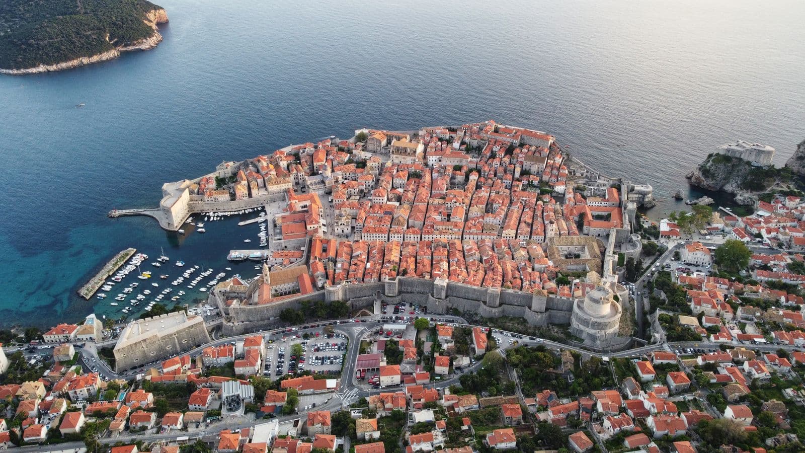 Dubrovnik's walled old town and harbour from the air, parking loops visible outside the walls