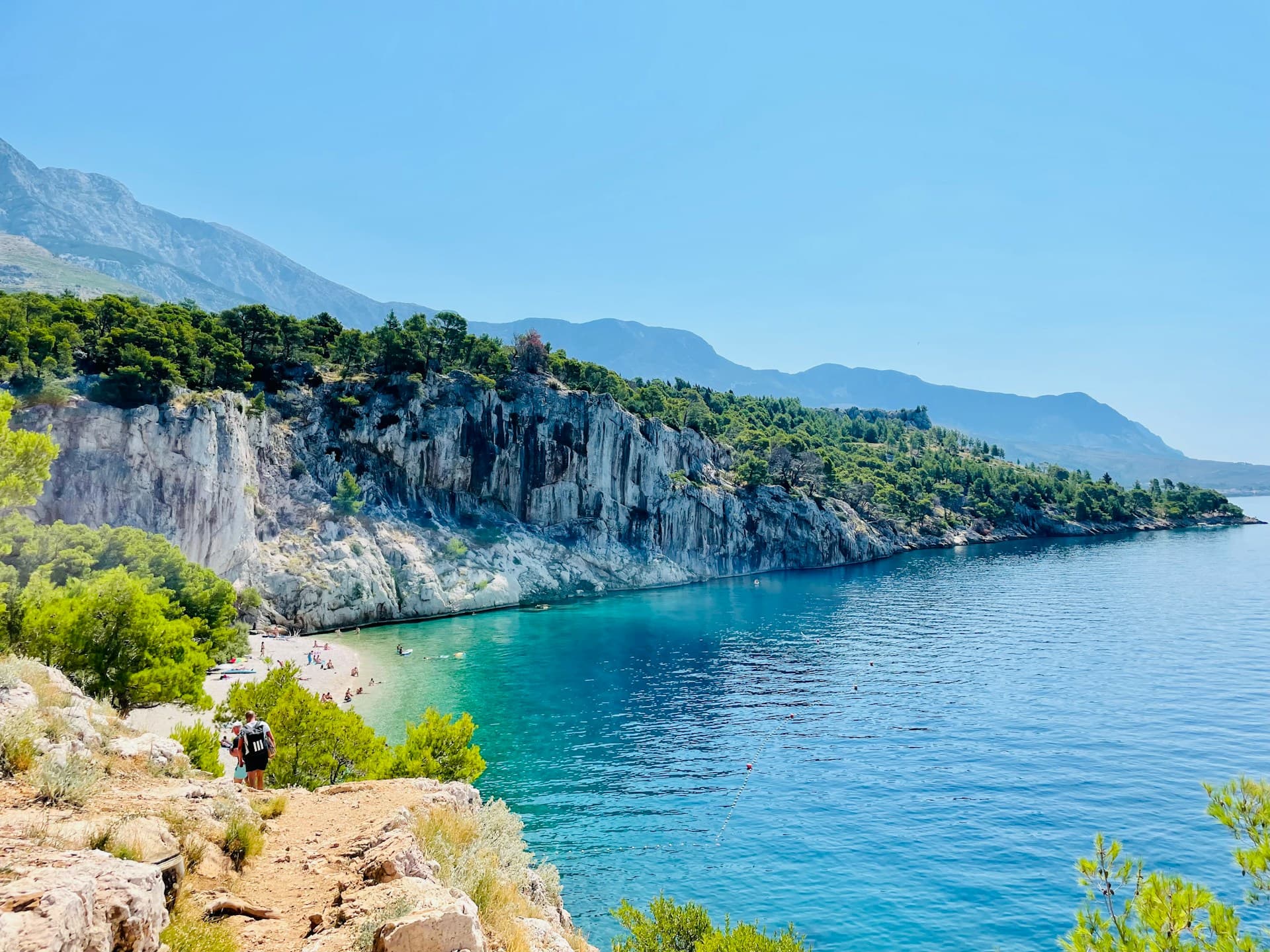 A turquoise pebble cove below white cliffs on the Makarska Riviera