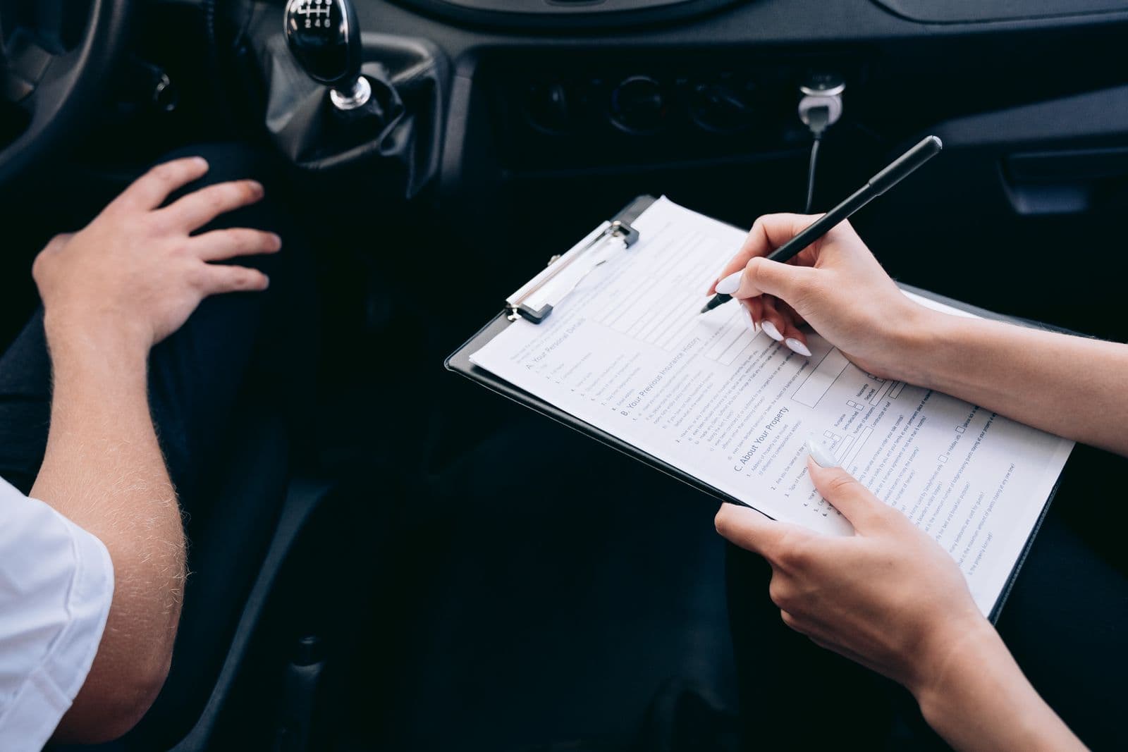 Filling in the rental paperwork on a clipboard in the front seat