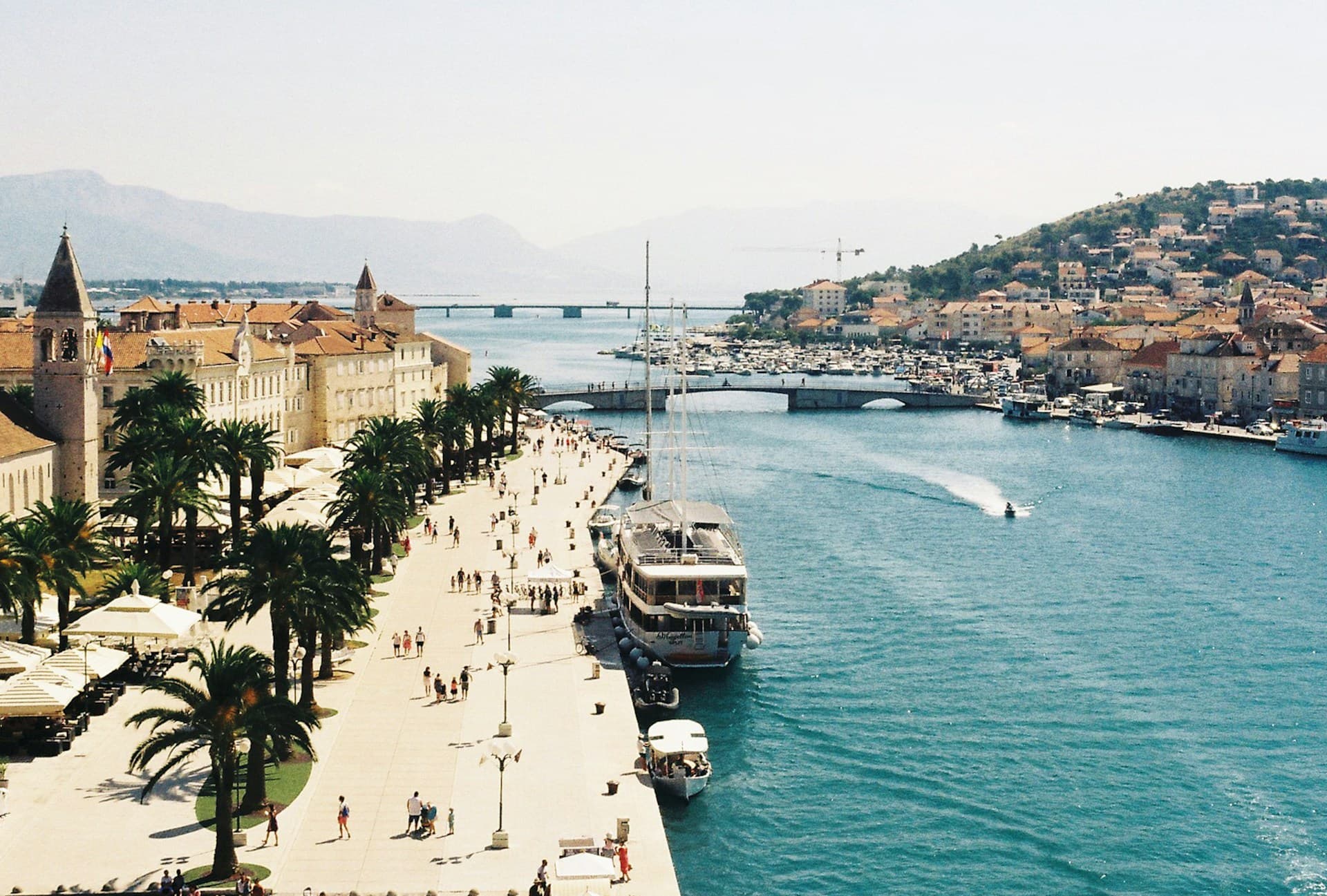 Trogir's palm-lined riva and harbour with the Ciovo bridge, from above