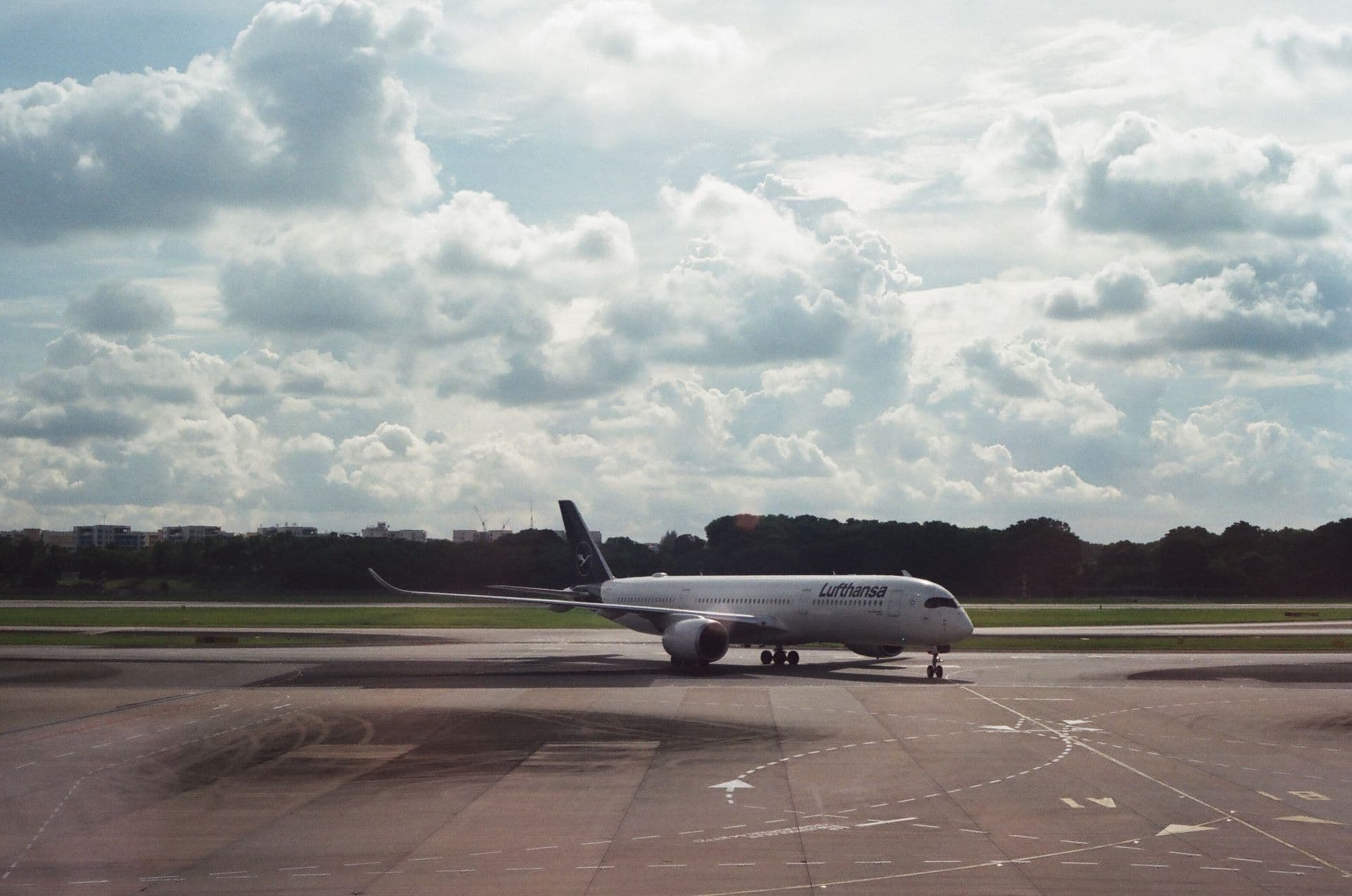 A passenger jet taxiing on the apron under a cloudy sky